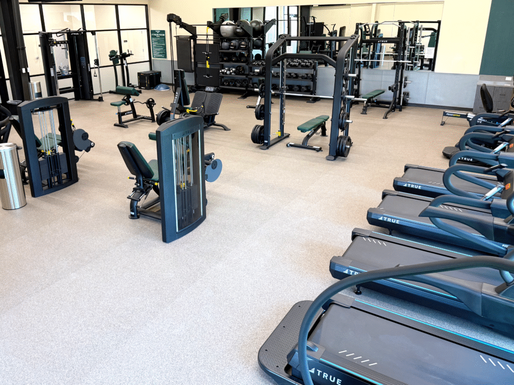 Commercial fitness room featuring treadmills and strength machines maintained through regular professional service.