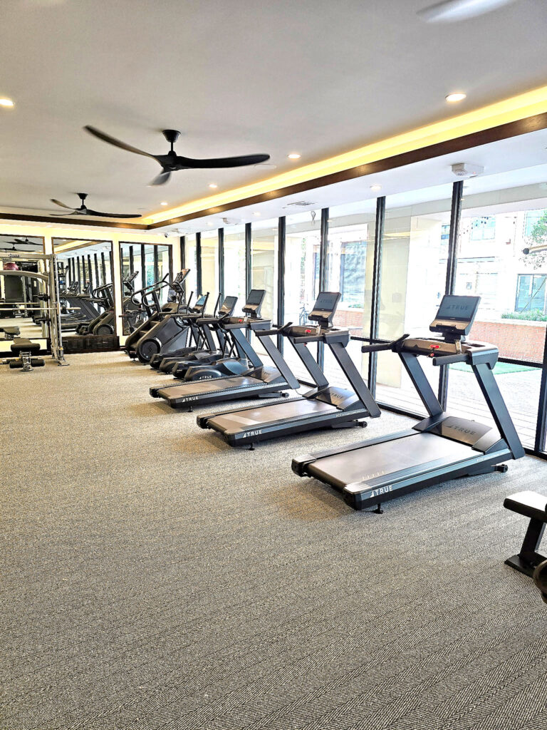 TRUE treadmills and ellipticals installed in a bright country club fitness center.