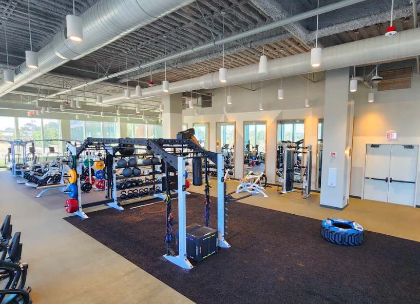 Commercial gym with functional training equipment and free weights.