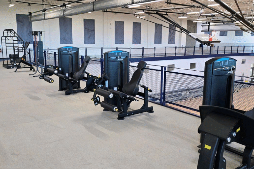 Parks and recreation fitness facility with TRUE strength training equipment overlooking a gymnasium.