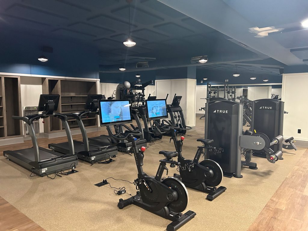 Fitness room with treadmills, bikes, and strength machines indicating need for professional inspection.